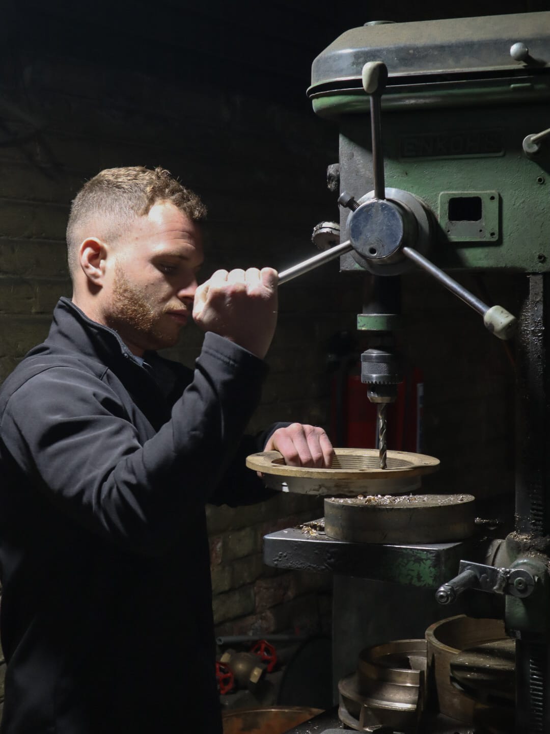 An AGP team member working at a pillar drill